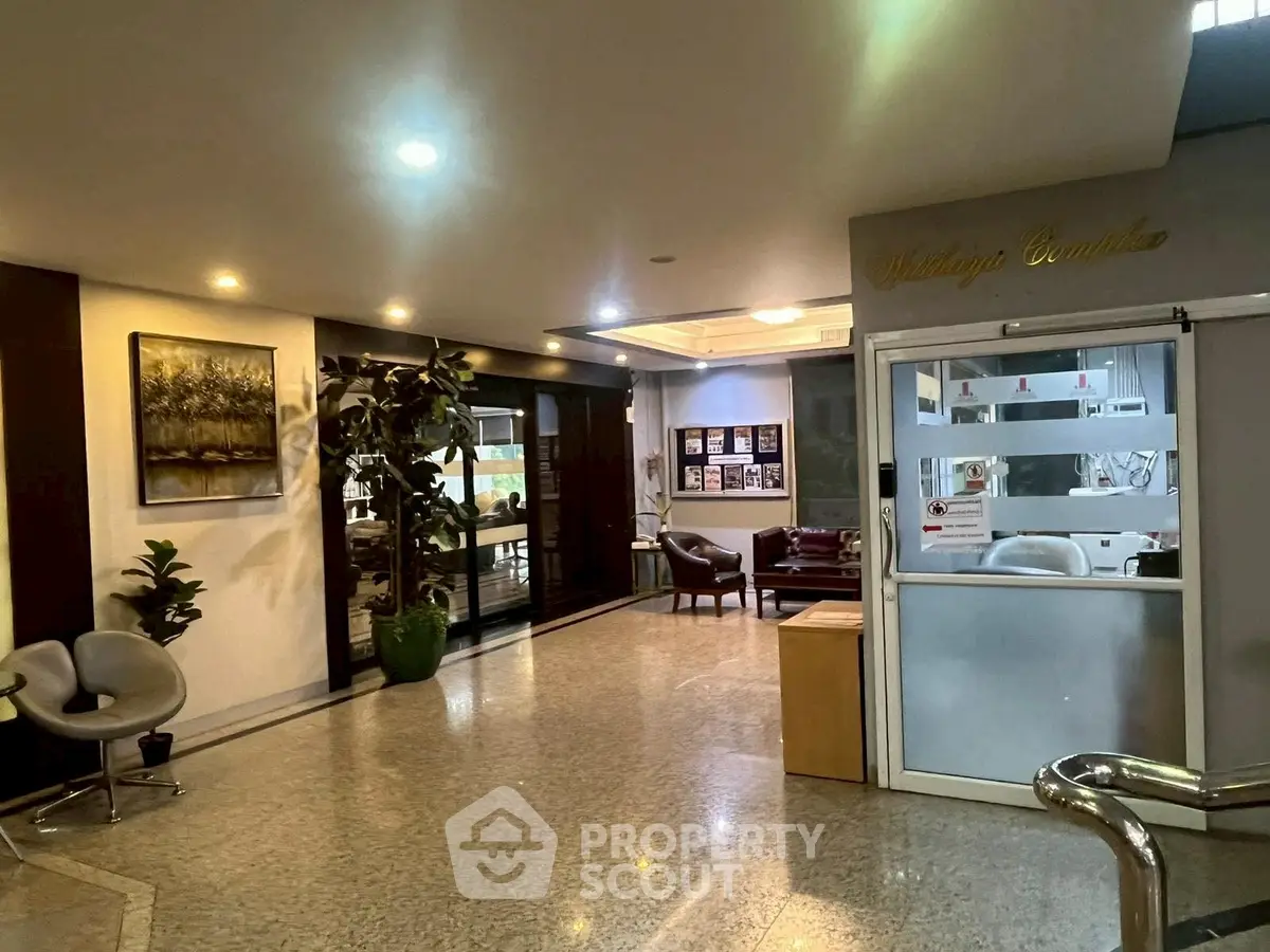 Elegant building entrance with modern decor and seating area, perfect for welcoming guests.