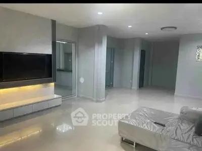 Spacious modern living room with sleek design and large TV unit, perfect for relaxation.