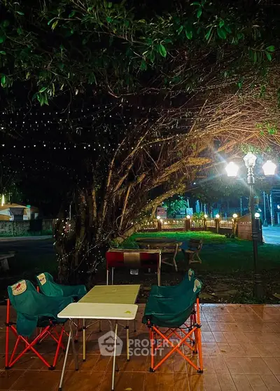 Charming outdoor patio with cozy seating under twinkling lights, perfect for evening relaxation.