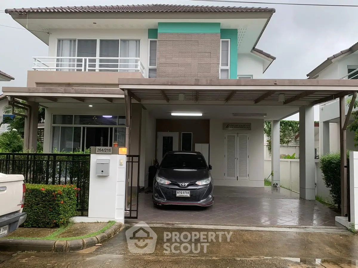 Modern two-story house with carport and lush greenery in a serene neighborhood.