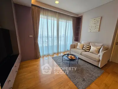 Modern living room with cozy sofa and large window offering natural light and city view.