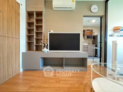Modern living room with sleek TV stand, wooden flooring, and stylish decor in a contemporary apartment.