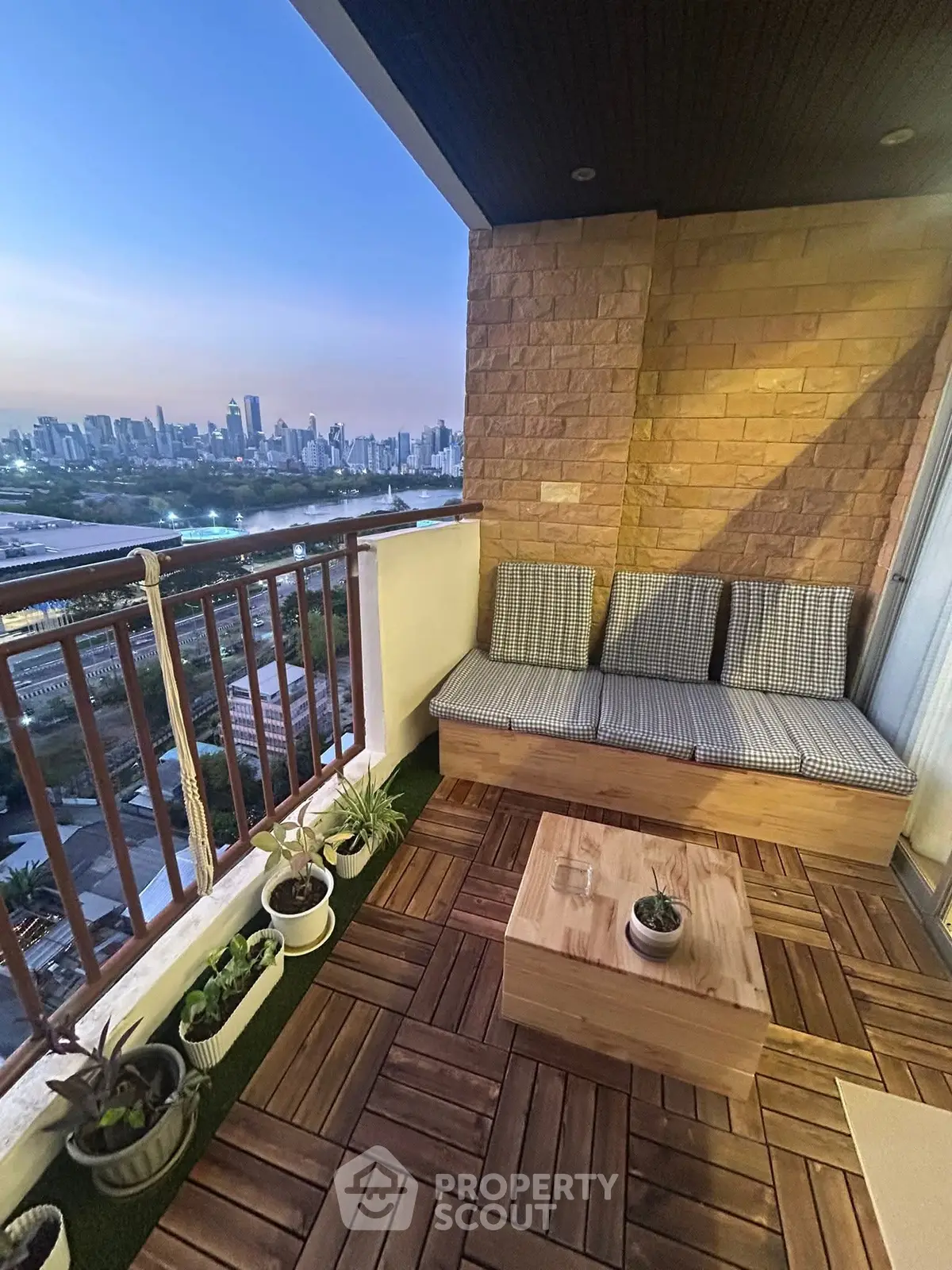 Charming balcony with city skyline view, cozy seating, and stylish wooden flooring.
