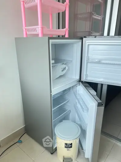 Modern kitchen with sleek refrigerator and ample storage space, perfect for contemporary living.