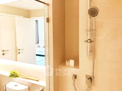 Modern bathroom with sleek shower and elegant fixtures in luxury apartment.