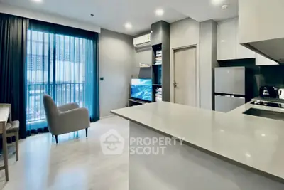 Modern open-plan living room and kitchen with sleek design and natural light.