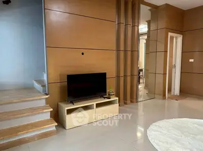 Modern living room with sleek wooden paneling and stylish TV setup.