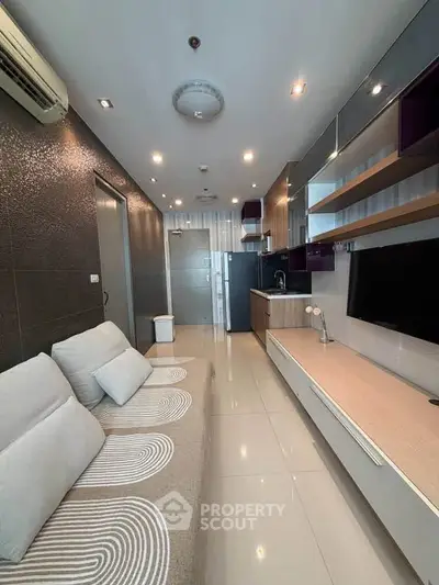 Modern living room with sleek design and integrated kitchen area, featuring stylish furniture and ambient lighting.