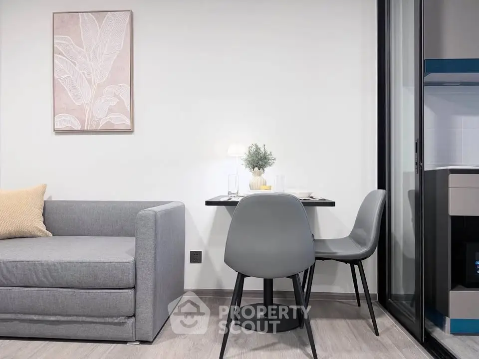 Modern living room with sleek gray sofa and dining area, perfect for urban living.
