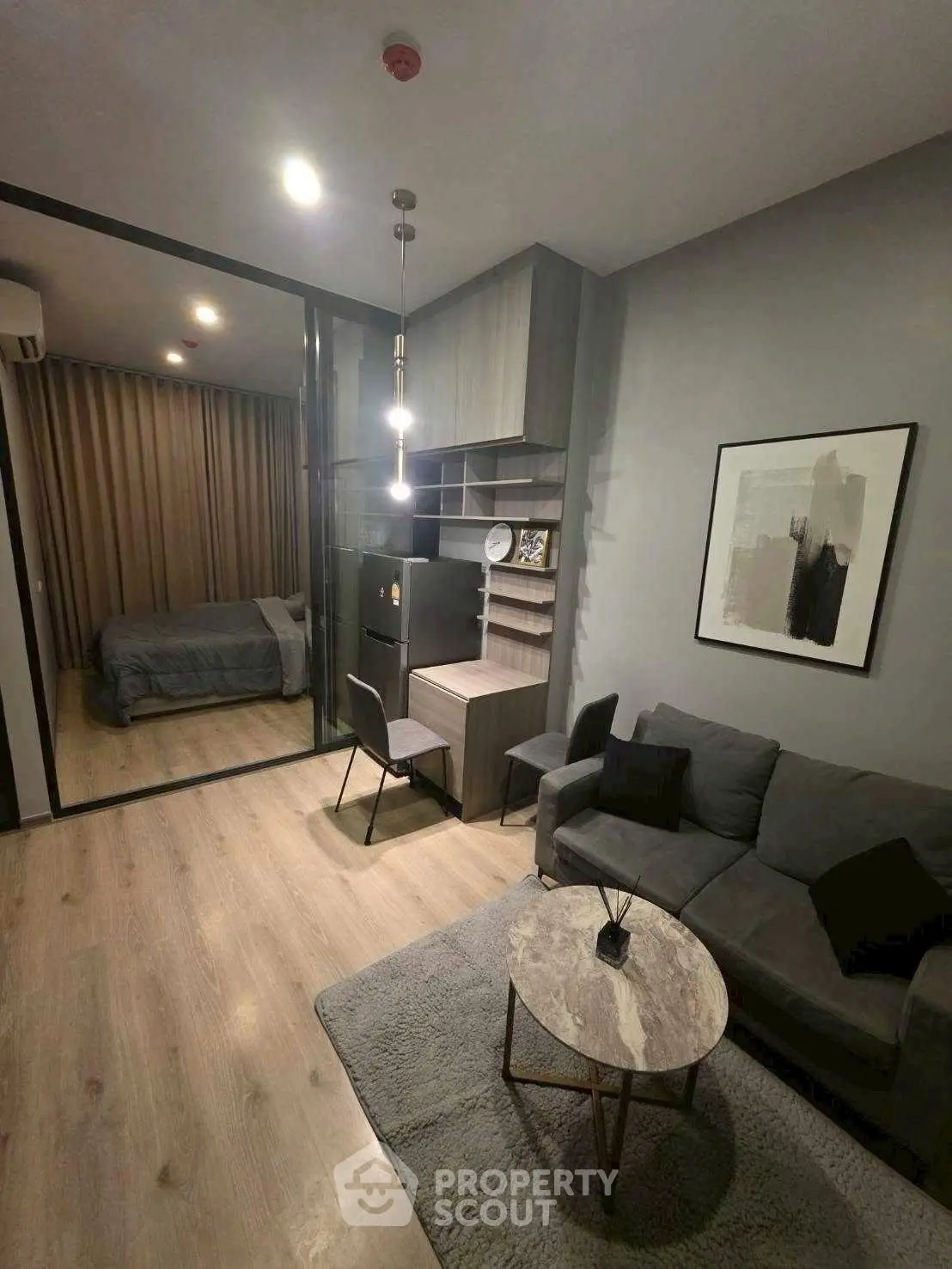 Modern living room with cozy seating and stylish decor adjacent to a bedroom.