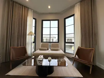 Elegant living room with modern furniture and large windows offering natural light
