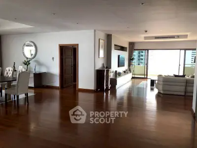 Spacious open-plan living room with elegant dining area and balcony view.