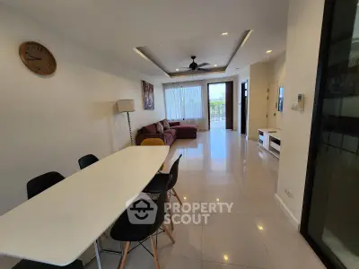 Spacious modern living room with elegant dining area and natural light.