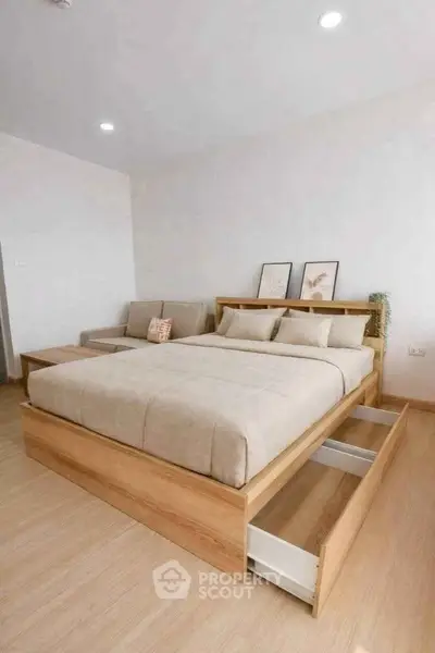 Modern bedroom with stylish wooden bed frame and cozy seating area, perfect for relaxation.