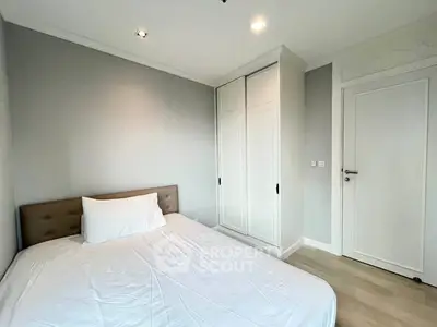 Modern minimalist bedroom with white wardrobe and cozy bed in a bright apartment.