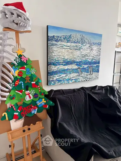 Cozy living room with festive decor and mountain landscape painting.