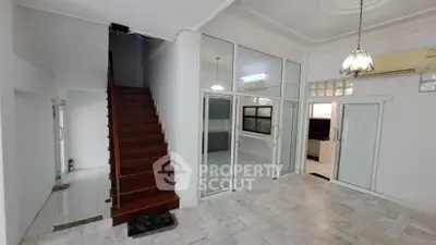 Spacious interior with elegant staircase and glass doors, perfect for modern living.