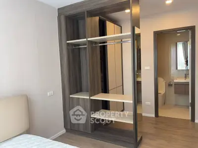 Modern bedroom with open closet and en-suite bathroom in stylish apartment