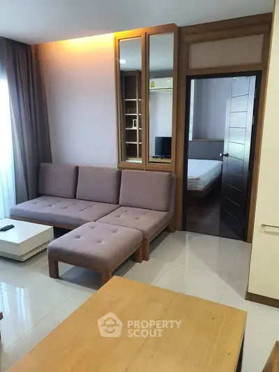 Modern living room with stylish furniture and open view to bedroom