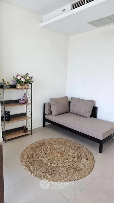 Cozy minimalist living room with a daybed and decorative shelf, perfect for relaxation.