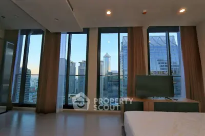Luxurious bedroom with stunning city view and floor-to-ceiling windows in modern high-rise.