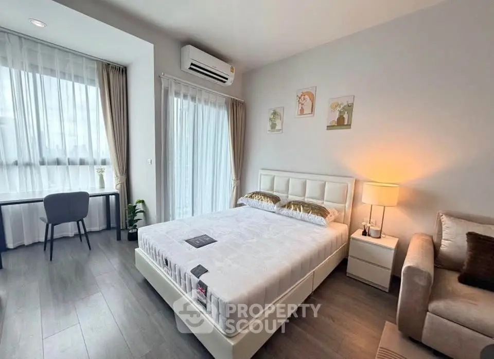 Modern bedroom with stylish decor, large windows, and cozy ambiance in a contemporary apartment.