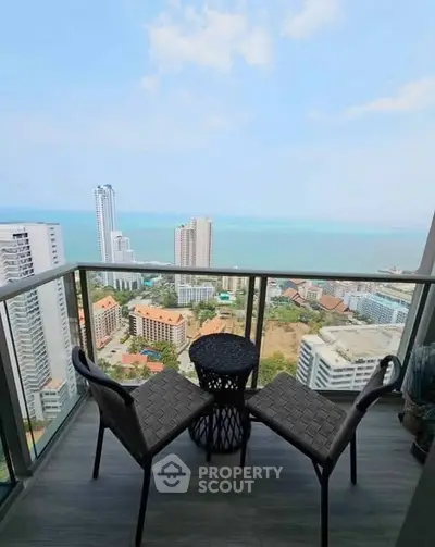 Stunning high-rise balcony with panoramic ocean view and modern seating.