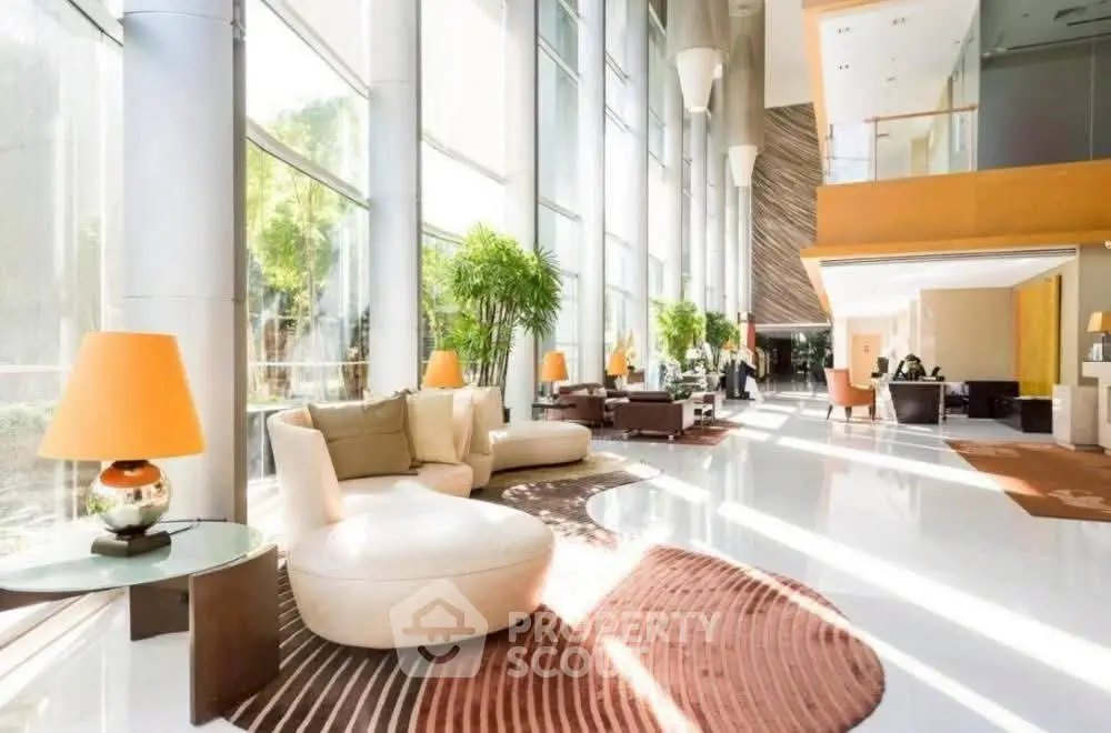 Luxurious modern lobby with elegant seating and floor-to-ceiling windows offering natural light.