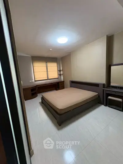 Spacious bedroom with modern furniture and natural light