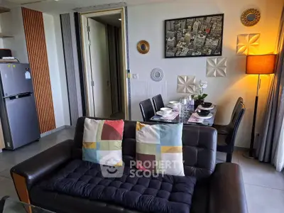 Modern living room with stylish decor and dining area, featuring a cozy sofa and elegant table setting.