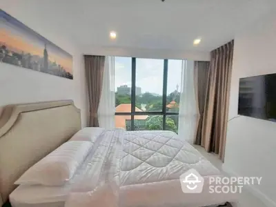 Spacious bedroom with large window offering scenic view and modern decor.