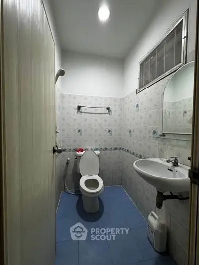 Compact bathroom with modern fixtures and blue tile flooring
