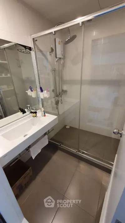 Modern bathroom with glass shower enclosure and sleek sink design