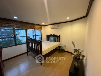 Spacious bedroom with wooden bed and air conditioning in a cozy apartment