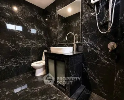 Luxurious black marble bathroom with modern fixtures and elegant design.