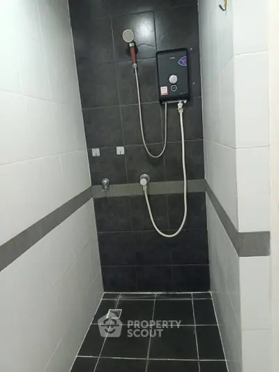 Modern bathroom shower area with sleek black and white tiles