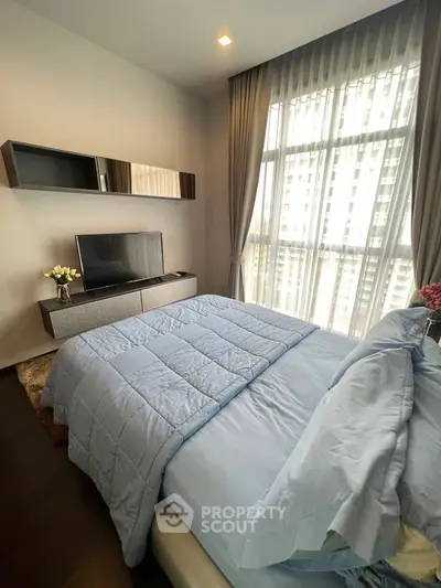 Modern bedroom with large window and stylish decor in a high-rise apartment.