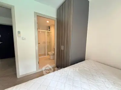 Modern bedroom with ensuite bathroom and built-in wardrobe in a stylish apartment.