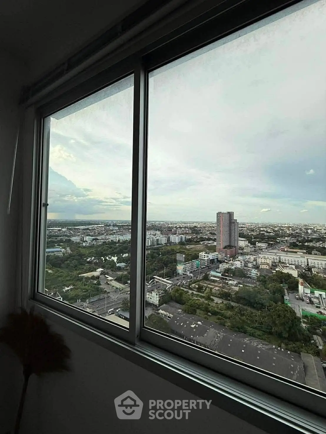 Stunning cityscape view from high-rise apartment window, showcasing urban skyline and expansive horizon.