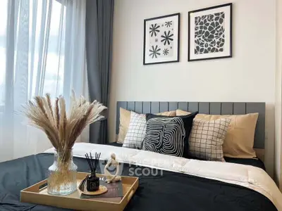 Stylish bedroom with modern decor and natural light, featuring elegant wall art and cozy bedding.