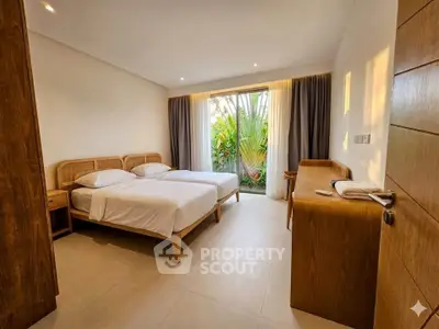 Spacious bedroom with twin beds and garden view, featuring natural wood furniture and soft lighting.