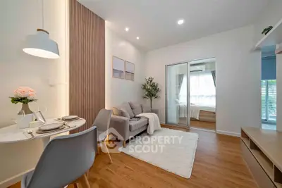 Modern living room with cozy dining area and view into a bright bedroom.