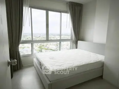 Bright bedroom with large window offering stunning city views and modern furnishings.