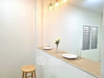 Minimalist kitchen with wooden counter and modern lighting