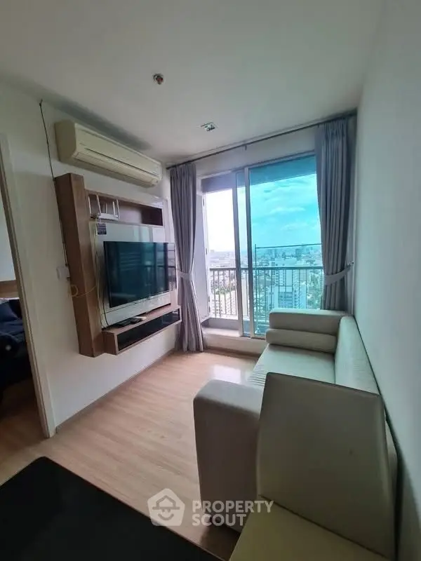 Modern living room with city view, featuring sleek furniture and large windows for natural light.