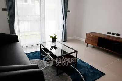 Modern living room with sleek furniture and large window for natural light.