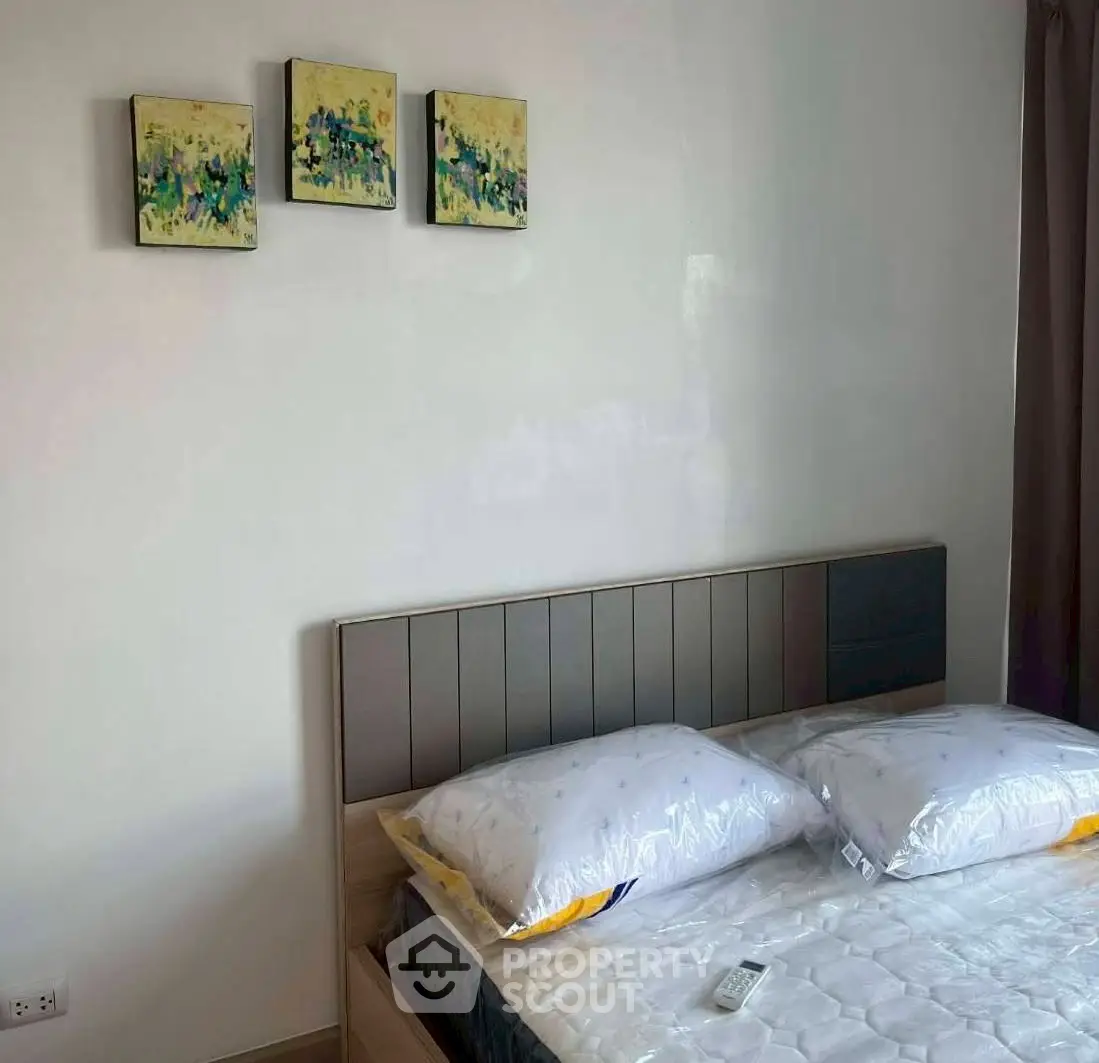 Modern bedroom with stylish headboard and abstract art, perfect for a cozy retreat.