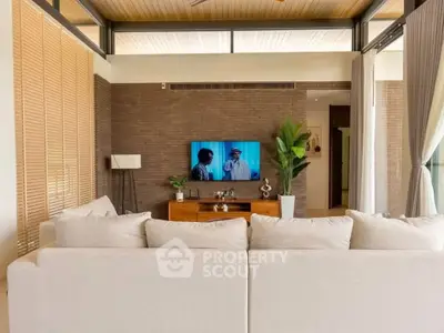 Luxurious living room with modern decor and large TV, perfect for relaxation and entertainment.
