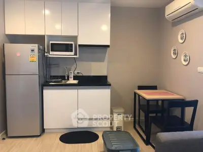 Modern compact kitchen with dining area, featuring sleek cabinetry and stainless steel appliances.
