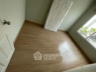 Spacious empty room with wooden flooring and large window view
